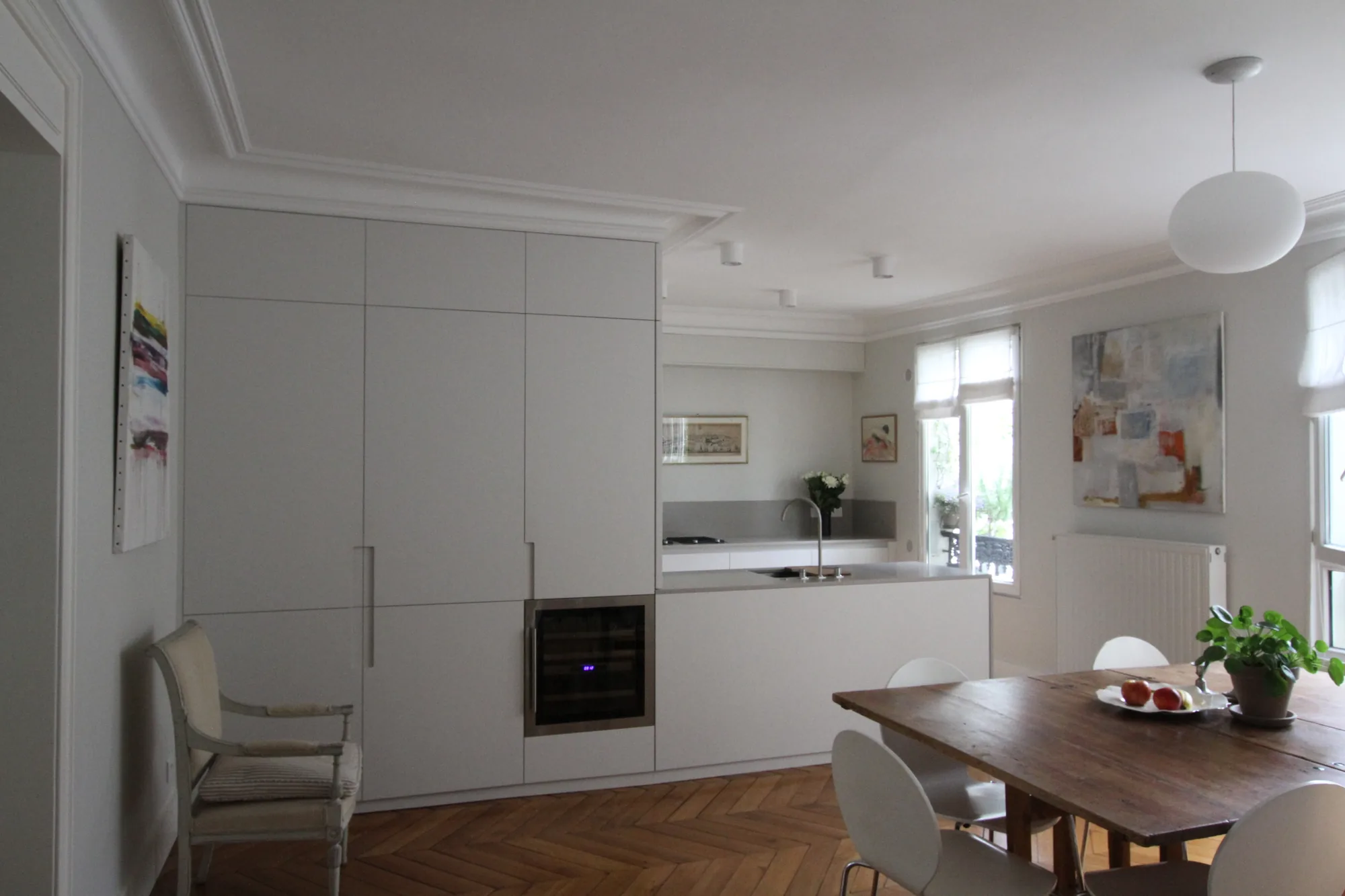 Îlot en pierre claire et laque blanche face aux fenêtres, clarté haussmannienne, appartement Paris 16e Iéna